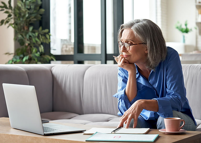 Mature woman planning her month from her couch